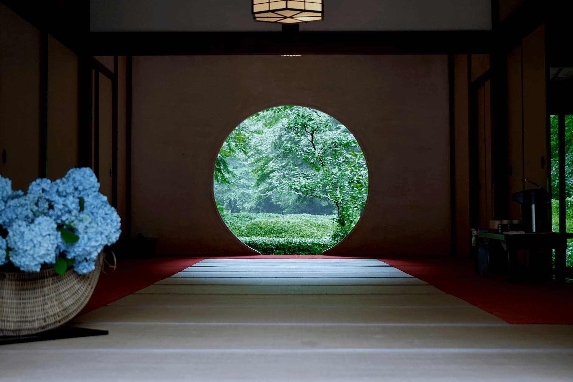 Japanese temple room with round window overlooking a garden